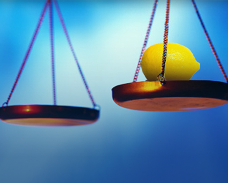 A lemon placed on one side of a balance scale.